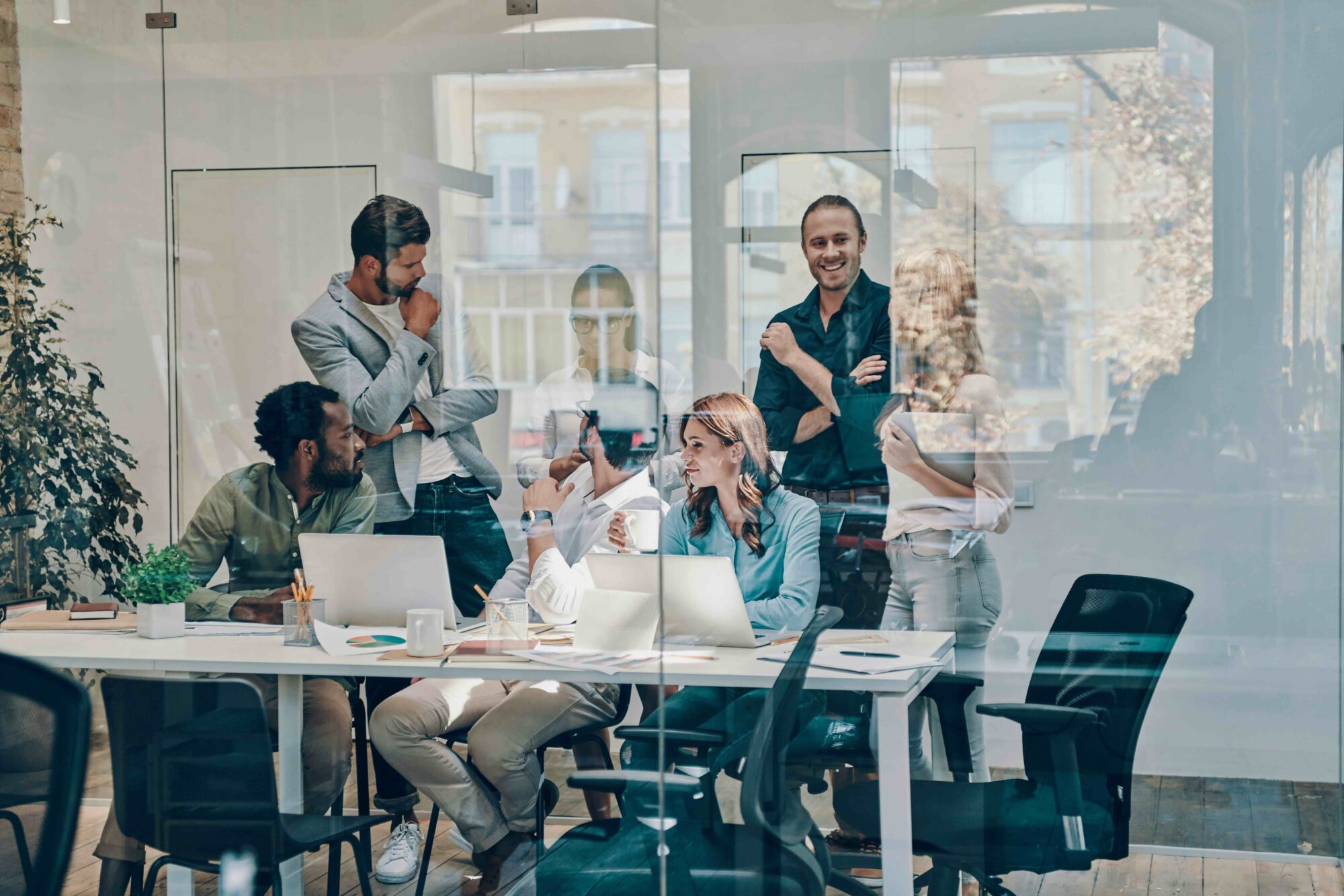 Professional team in conference room behind glass wall