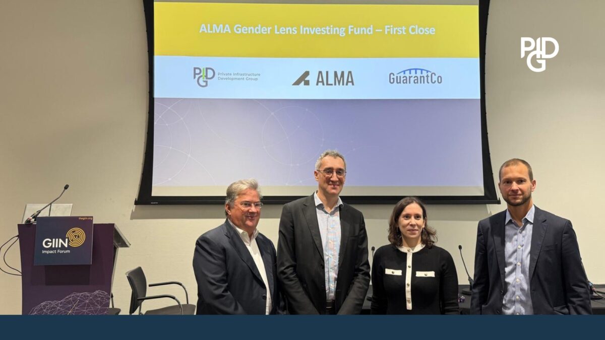 Four people stand beneath a screen reading “ALMA Gender Lens Investing Fund – First Close,” with the PIDG, ALMA and GuarantCo logos, beside a GIIN Impact Forum lectern.